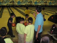 Young kids learning how to bowl and having a good time